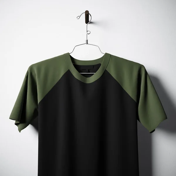 Primo piano di bianco nero e verde cotone tshirt appesa al centro muro di cemento vuoto. Mockup etichetta chiara con materiali testurizzati altamente dettagliati. Quadrato. Vista frontale laterale. Rendering 3D . — Foto Stock