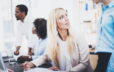 Grup dört iş ofiste iş projesi tartışıyor. Güzel kadın meslektaşı ile söz. Yatay, bulanık arka plan.