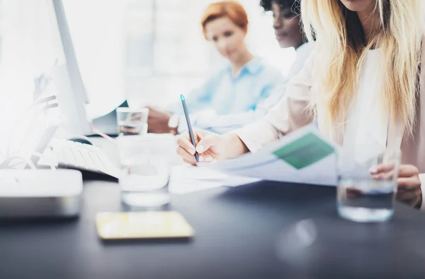 Close-up van jonge meisjes collega's bespreken samen zakelijk project. Mooie blonde vrouw ondertekenen document op werkplek op kantoor. Horizontale, onscherpe achtergrond. — Stockfoto