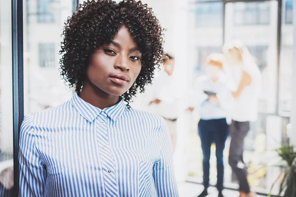 Portret lidera młodych piękne afrykańskich kobiet biznesu z zespołu stojący na tle w nowoczesnym biurze. Poziome, niewyraźne. — Zdjęcie stockowe