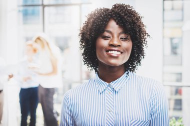 Genç mutlu siyah kadın ofis çalışanı modern coworking Studio arka planda iş ekiple portresi. Yatay, bulanık.