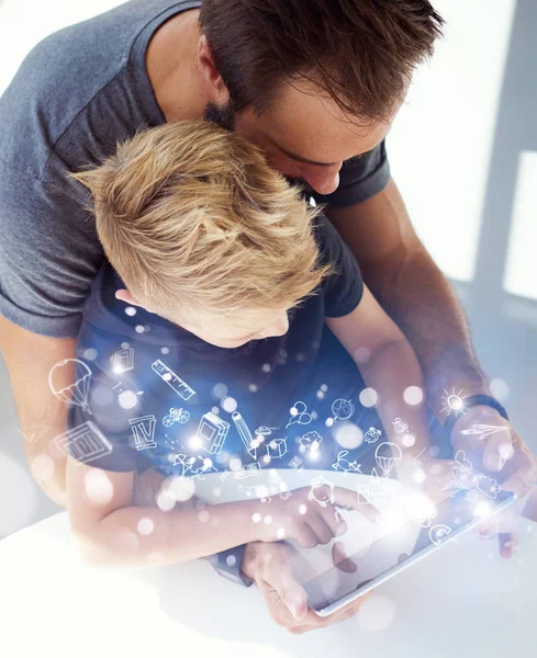 Dad and little boy playing together on mobile computer PC tablet, resting in modern house.Childhood dreams icons concept.Vertical, blurred background. Top view. — Stock Photo, Image