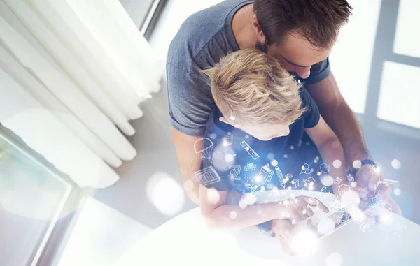 Papà e bambino che giocano insieme su tablet PC mobile, riposando in casa moderna.Infanzia sogni icone concettuale.Orizzontale, sfondo sfocato. Vista dall'alto . — Foto Stock