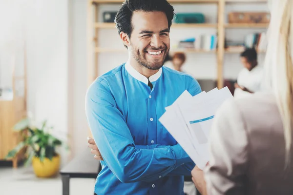 Twee collega's, het maken van een groot zakelijk project gesprek in moderne kantoor. Succesvolle vertrouwen Spaanse zakenman in gesprek met jonge vrouw. Horizontale, onscherpe achtergrond. — Stockfoto