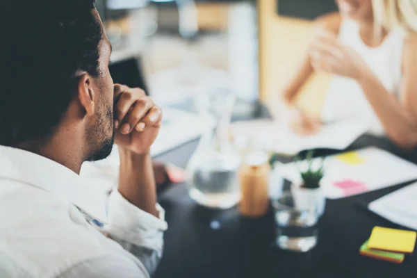 Nahaufnahme eines schwarzafrikanischen Projektmanagers während eines Geschäftstreffens in einem modernen Büro. Horizontaler, verschwommener Hintergrund. — Stockfoto