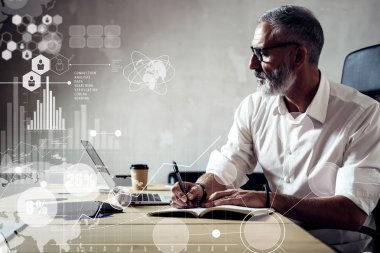 Küresel sanal simge, diyagram, grafik arabirimleri ile dijital ekran kavramı. Klasik gözlüklü ve modern çatı katında ahşap masa laptop üzerinde çalışan yetişkin başarılı iş adamı. Yatay.