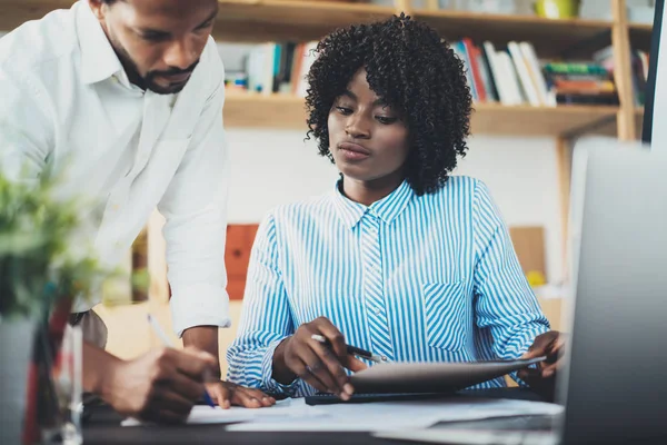 Two young business people working together in a modern office.Black man discussing with colleague new project.Horizontal,blurred. — Stock Photo, Image