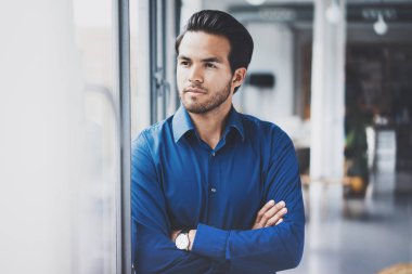 Modern ofis penceresinden yakın duran başarılı emin İspanyol işadamı portresi. Yatay, bulanık arka plan.