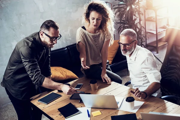 Equipo joven de empresario acertado que hace la gran discusión en estudio moderno del coworking. Hombre barbudo que habla con colegas sobre el proyecto de la puesta en marcha. Concepto de la lluvia de ideas de la gente del negocio. Horizontal, llamarada . —  Fotos de Stock