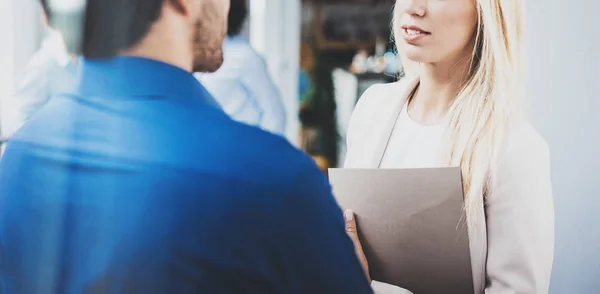 Twee collega's bespreken van business strategie in moderne kantoor. Succesvolle vertrouwen Spaanse zakenman praten met blonde vrouw. Horizontale close-up, onscherpe achtergrond. — Stockfoto