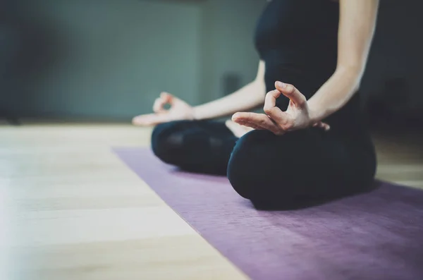 Vista de cerca de la joven mujer medita mientras practica yoga en una sala de entrenamiento. Concepto de libertad. Tranquilidad y relax, felicidad femenina.Horizontal, jardín borroso en el fondo . —  Fotos de Stock