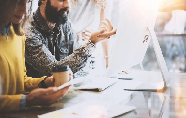 İş arkadaşlarınızla birlikte modern coworking ofisinde çalışan genç takım. Meslektaşı ile yeni başlangıç projesi hakkında konuşan sakallı adam. İş adamları kavramı beyin fırtınası. Yatay, parlama efekti.