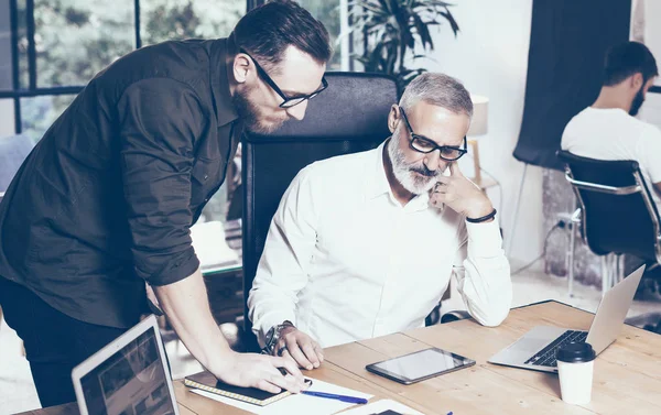 Concept de présentation d'un nouveau projet d'entreprise.Jeune homme barbu discuter des idées avec le gestionnaire de compte dans le bureau moderne.Horizontal, fond flou, effet film . — Photo