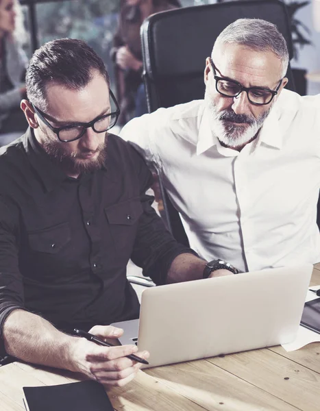 턱수염이 난된 남자는 새로운 시작 프로젝트에서 일 하는 동료와 함께 노트북을 함께 사용 하 여. 비즈니스 사람들이 팀워크 개념. 수직, 흐리게. — 스톡 사진