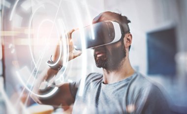 Dijital ekran, bağlantı arabirimlerinin kavramı. Sanal gerçeklik giyen sakallı adam modern iç tasarım stüdyo coworking gözlük. Vr ile Smartphone kullanarak kulaklık gözlükler. Arka plan bulanık.