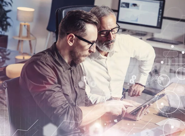 Concepto de pantalla digital, icono de conexión virtual, diagrama, interfaces gráficas.Hombre de negocios adulto que trabaja junto con un socio joven en la mesa de madera en la oficina moderna.Uso de dispositivos móviles.Bengalas . — Foto de Stock