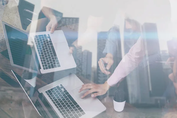 Dubbele blootstelling van jonge collega's werken samen aan nieuw opstarten project in moderne plaats. Mensen uit het bedrijfsleven met behulp van mobiele gadgets. Wolkenkrabber kantoorgebouw op de onscherpe achtergrond. Horizontale, flare. — Stockfoto