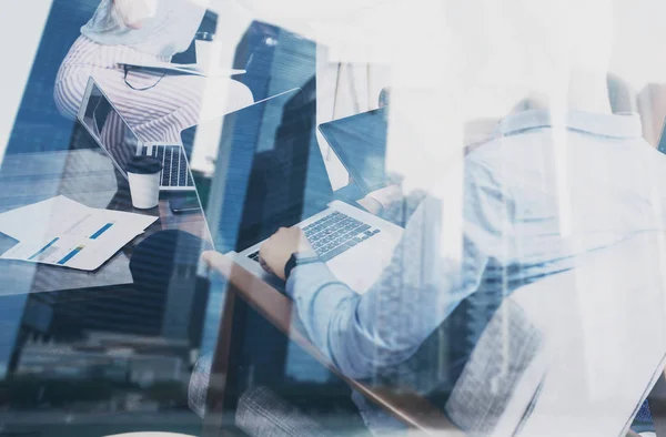 Young coworker working laptop on startup project in modern place.Teamwork business concept.Skyscraper office building at the blurred background.Horizontal closeup,double exposure. — Stock Photo, Image