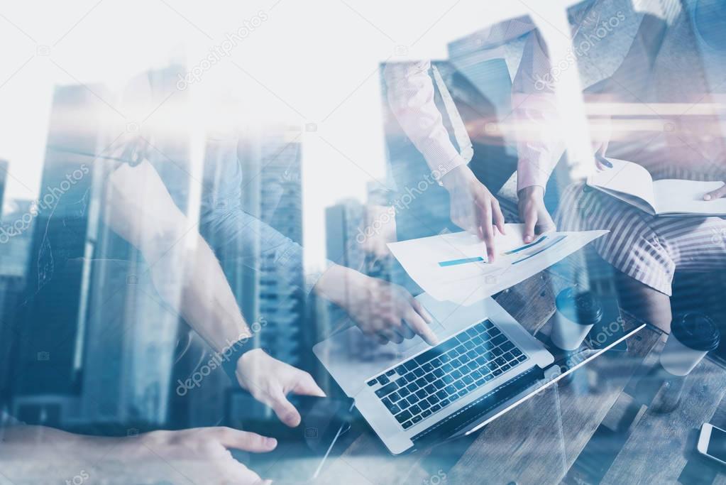 Double exposure of young coworkers working together on new startup project in modern office.Business people brainstorming concept.Skyscraper building at the blurred background.Horizontal,flare effect.