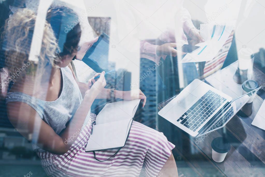 Team of young hipsters working laptop on startup project in modern place.Teamwork business concept.Skyscraper office building at the blurred background.Horizontal closeup,double exposure.