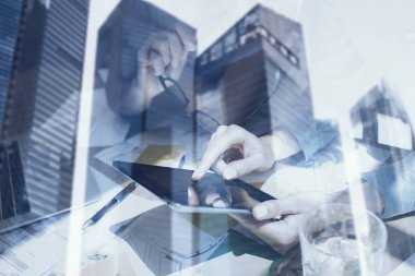 Ekran elektronik tablet dokunmadan eller closeup görünümü. Kavram iş adamları mobil araçları kullanma. Çift pozlama, modern gökdelen ofis binası arka plan bulanık. Yatay.