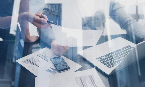 Vue rapprochée de l'équipe d'affaires travaillant ensemble dans un lieu de coworking Concept jeunes gens faisant un nouveau projet de démarrage.Double exposition, gratte-ciel immeuble de bureaux arrière-plan flou . — Photo