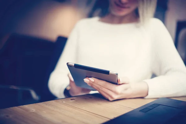 Junges schönes Mädchen mit digitalem Tablet am Holztisch. Konzept der Coworking People arbeiten mit mobilen Geräten. Horizontaler, verschwommener Hintergrund. Filmeffekt. — Stockfoto