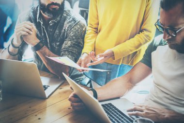İş arkadaşlarınızla birlikte modern coworking ofisinde çalışan genç grup. Meslektaşı ile yeni başlangıç projesi hakkında konuşan sakallı adam. İş adamları kavramı beyin fırtınası. Yatay, bulanık.