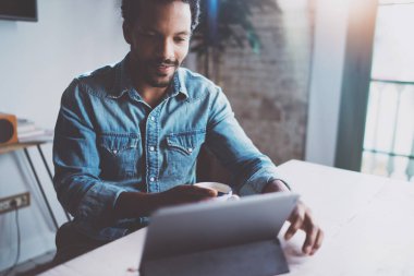 Afrika delikanlı arkadaş grubu dijital tablet üzerinden görüntülü görüşme konuşma modern ofis masasında otururken olsun diye gülümsüyor. Mutlu iş adamları kavramı. Arka plan bulanık film etkisi.