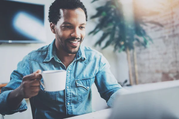 Güneşli toplantı odasında otururken video dijital tablet ile iş ortakları ile muhabbet çekici Afrika adam gülümsüyor. Mutlu coworking insanlar kavramı. Arka plan bulanık, fişekleri. — Stok fotoğraf