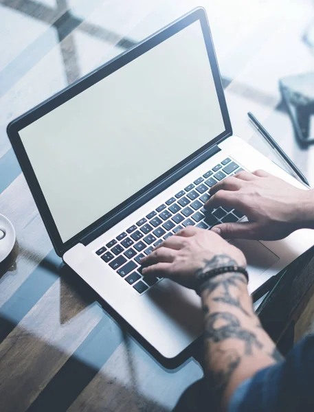 Jovem colega tatuado trabalhando no laptop — Fotografia de Stock