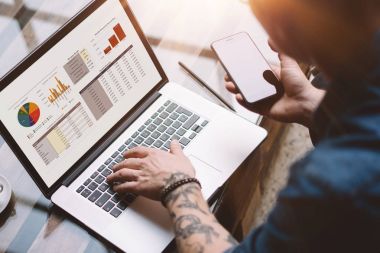 dövmeli iş arkadaşınız çalışırken dizüstü bilgisayar kullanarak