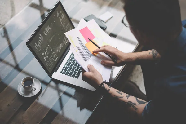 Erwachsener tätowierter Mitarbeiter arbeitet mit Laptop — Stockfoto