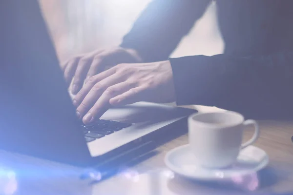 Man in zwarte shirt werken met laptop — Stockfoto