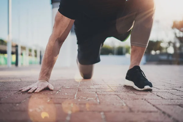 Outdoor-Workout-Lifestylekonzept. Junger Mann, der Dehnübungen macht, trainiert Muskeln vor dem Training. Muskulöser Athlet, der draußen im sonnigen Park trainiert. verschwommener Hintergrund.. — Stockfoto