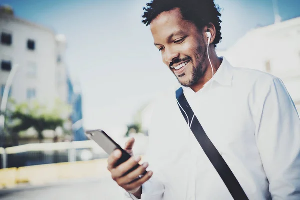 Hombre en auriculares caminando en la ciudad — Foto de Stock