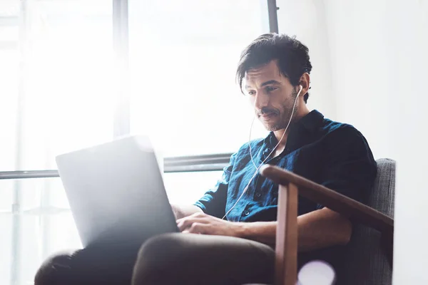 Uomo d'affari in cuffia che lavora su laptop — Foto Stock