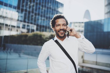 Güneşli city adlı onun arkadaş aramak için akıllı telefon kullanan mutlu Amerikan Afrika adam portresi. Mutlu genç yakışıklı insanlar becerikli alet açık zevk kavramı. Arka plan bulanık.