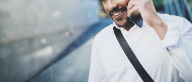 Güneşli Sokağı'nda arkadaş aramak için akıllı telefon kullanan mutlu Amerikan Afrika adam portresi. Mutlu genç insanlar becerikli alet açık havada zevk kavramı. Arka plan bulanık. Yatay geniş, kırpılmış.