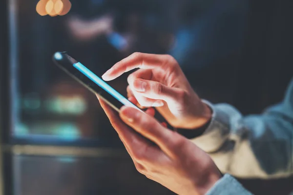 Closeup view of woman holding modern smartphone in hands.Girl typing on empty mobile screen. Horizontal, blurred background, bokeh effects. — Stock Photo, Image