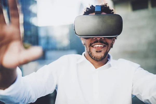 Concept of technology,gaming,entertainment and young people.Closeup view of Smiling american african man enjoying virtual reality glasses or 3d spectacles.Blurred background.Horizontal. — Stock Photo, Image