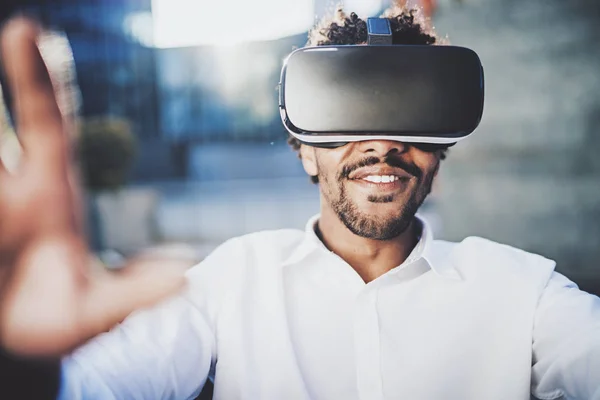 Begreppet teknik, spel, underhållning och ungdomar. Ler amerikansk afrikanska man njuter av virtual reality-glasögon. Suddig bakgrund. Horisontell. — Stockfoto