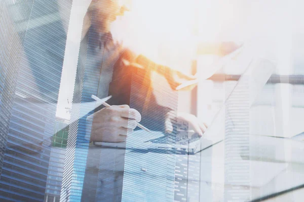 Workers using laptop and skyscrapers — Stock Photo, Image