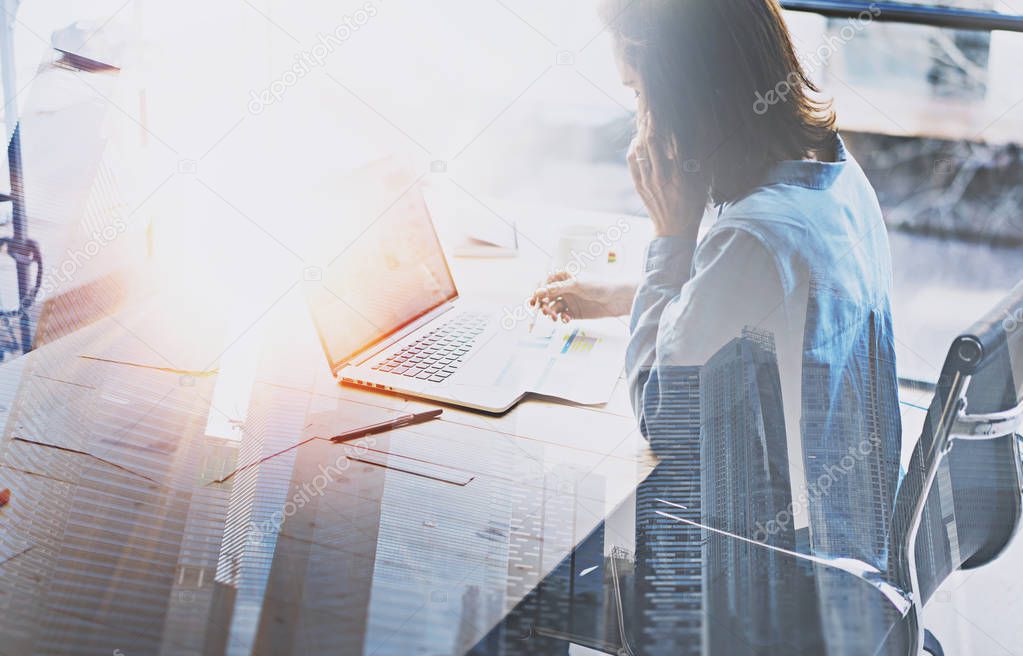 Businesswoman working at office and skyscrapers