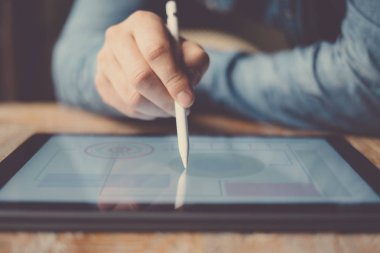 Elektronik kalem ve tabla kullanan adam