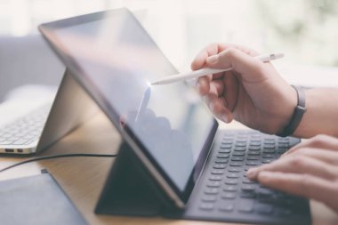 Elektronik kalem ve tabla kullanan adam