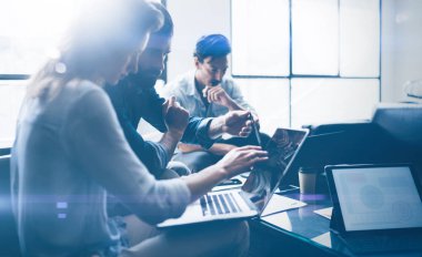 Ekip çalışması işlem kavramı. Genç arkadaşları yeni başlangıç projesi ofiste çalışmak. Modern dizüstü kullanarak tablo, kağıtları, belge iş adamları. Yatay, bulanık arka plan.