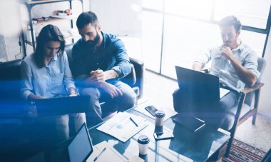 Ekip çalışması süreci. Genç arkadaşları yeni başlangıç projesi ofiste çalışmak. Modern dizüstü tablo, kağıtları, belgeler üzerinde. Yatay, bulanık arka plan.