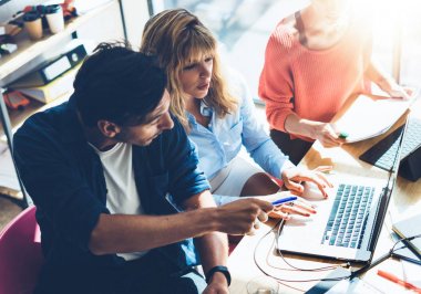 Ekip çalışması işlem kavramı. Yeni başlangıç proje Office ile genç arkadaşları ekip çalışması. Belge, planları analiz. Ahşap masa, kağıtları, belgeleri modern laptop. Yatay, bulanık arka plan.