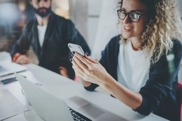 Collega's werken proces foto. Jong meisje in bril werken samen met bebaarde collega bij nacht moderne kantoor loft. Teamwork concept. Onscherpe achtergrond. Horizontale closeup. — Stockfoto